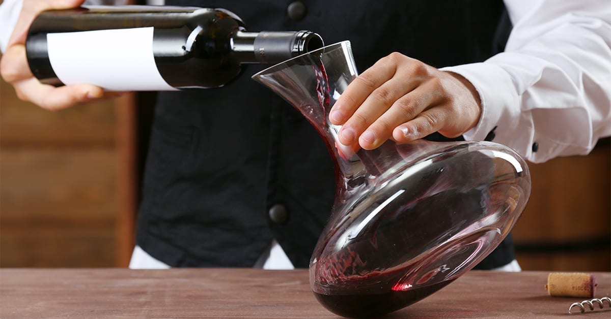 waiter decanting a bottle of wine